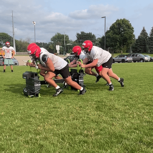 Football Players Pushing Team Sled